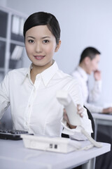 Obraz premium Businesswoman holding telephone receiver