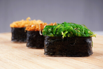 3 pieces of Japanese sushi on wooden platter