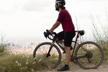 Fototapeta na wymiar Detail of a cyclist grasping the handlebars of a road bike observing the city of Barcelona