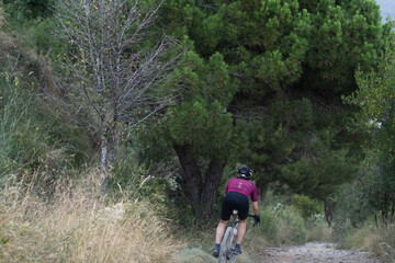 Fototapeta na wymiar Cyclist man going down a trail with a gravel bike