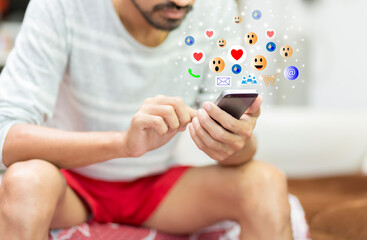 young man using smartphone with social media icons during stay at home, Concept social media, work from home, stay at home and social distancing