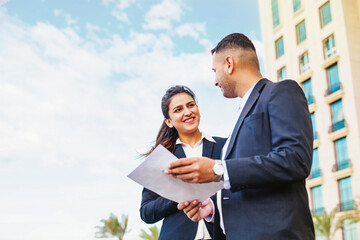 Two business people discussing the contract outside the office building