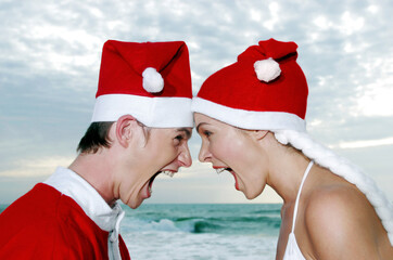 Obraz premium Side shot of a guy and lady in Santa suit screaming at each other