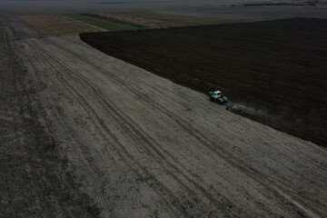 Tractor plows a field, aerial view. Agricultural landscape.