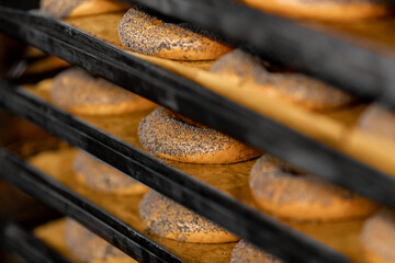 Bagels with poppy seeds are baked in oven. Industrial food production line