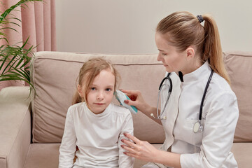 The doctor checks the girl hearing. Using an otoscope.