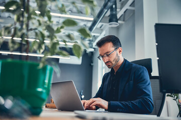 Attractive young guy is typing on computer