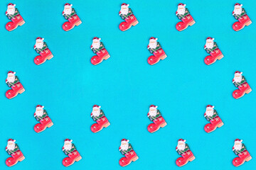 Fototapeta na wymiar Christmas pattern made with Santa Claus on blue background with copy space in the center. Minimal Christmas concept. Top view.