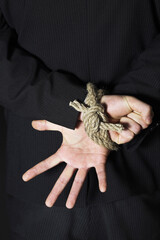 Businessman with his hands tied to the back