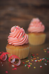 Delicious pink cupcakes on old wooden background