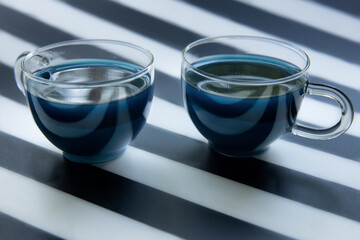 Obraz na płótnie Canvas geometry composition, blue butterfly tea with milk on black and white