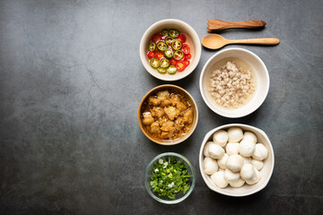 Fish ball, garlic cracklings with lard, mined pork, pickled chili, lime and coriander with spring onion various ingredients and condiment on table for noodles menu.