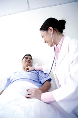 Doctor examining patient in a ward