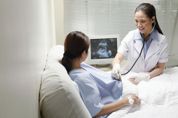 Fototapeta premium Female doctor checking on a pregnant woman
