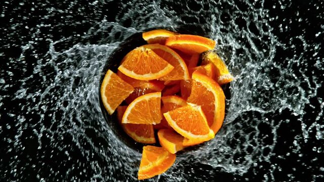 Fresh Oranges vortex with water splash on black background, slow motion filmed on high speed cinematic camera.