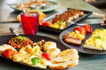 delicious red bean on the bread with potato and tomato,fried corn cobs with mushrooms on black plate vegan organic meal