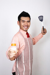 Businessman in apron holding baby bottle and ladle