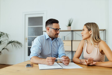 Handsome manager listening to a young businesswoman, portrait.