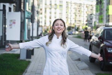 Fototapeta premium girl doctor in a white coat on the street