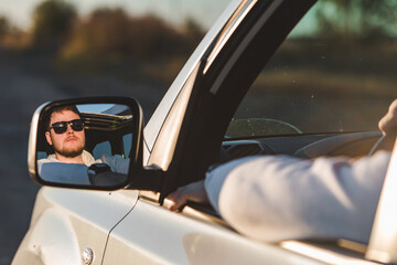 man stick out hand from car window. relaxed enjoying at sunset