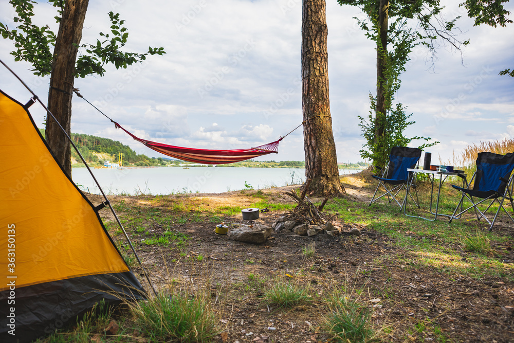 Wall mural view of camping near lake with hammock between trees