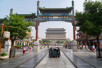 Zhengyang Gate. Tourists and workers walk in Qianmen Street. At the end of the street the archery tower of Zhengyang Gate Jianlou, sunny weather, vivid colours