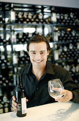 Man holding a bottle of wine and a wine glass