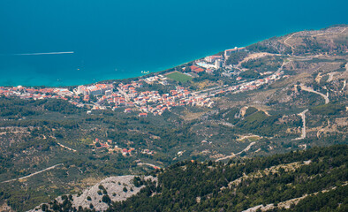 Naklejka premium Zoomed in view of the town of Tucepi, seen from the Biokovo mountain twenty kilometers away. Small town on the coast of adriatic sea