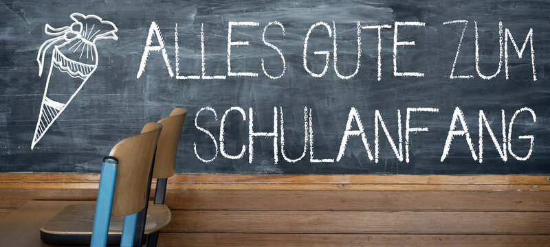 SCHULSTART Hintergrund Banner - Alte rustikale Schultafel und Holzst&uuml;hlen auf Holztisch, mit den Worten, ALLES GUTE ZUM SCHULANFANG und Schult&uuml;ten Zeichnung