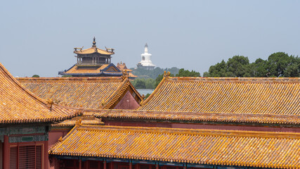 Fototapeta na wymiar Forbidden City close to Tiananmen Square, the large square near the center of Beijing, Gate of Heavenly Peace. Eaves of traditional oriental ancient buildings.Panoramic view Beihai Park in background