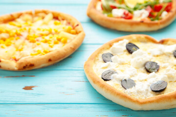 Variety of pizzas on blue wooden background