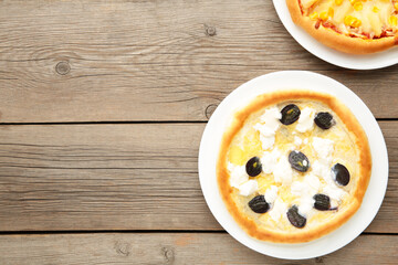 Delicious italian pizzas on grey wooden table with copy space