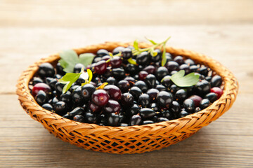 Basket with black currant on grey wooden background