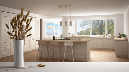 White table top or shelf with straws, dry plants, ornament, ears, sheaf, branch in vase, over wooden and white kitchen with accessories, modern minimal interior design