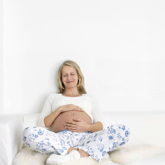 Obraz na płótnie Canvas Pregnant woman touching her stomach