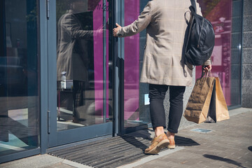 Stylish young man walking into the store