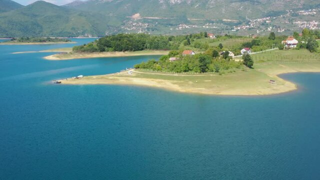 Northern shore of Rama Lake in Bosnia and Herzegovina area of Prozor with homes, Aerial dolly in shot