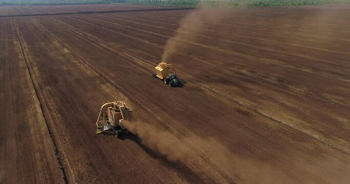 Peat harvesting machinery extracting peat turf in drained bog aerial view