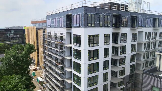 brand new building still in construction, 7 floors with out siding, been built aerial view close to the walls windows installed