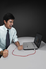 Businessman transferring blood from his hand to laptop through IV drip tube