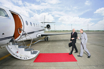 Businessmen walking towards private jet