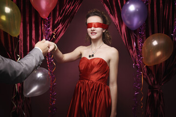 Man leading blindfolded woman by her hand