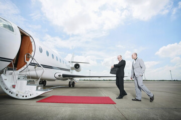 Businessmen walking towards private jet