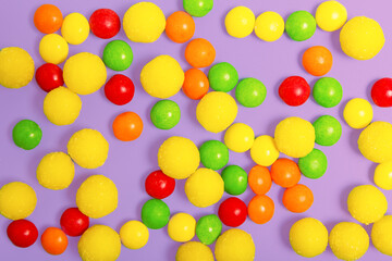multicolored round candies on a violet background. sweets store concept. Beautiful background for the designer. sweets concept for kids. flat lay.