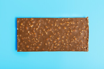 chocolate bars with nuts on a blue background. The concept of harmful sweet food and diet. The concept of sweets for dessert. background blank for designer. Minimalis, top view, copy space.
