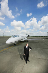 Businessman checking the time at private jet runway