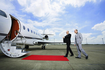 Businessmen walking towards private jet