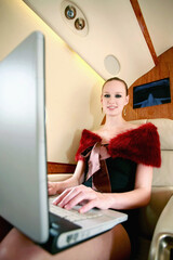 Fototapeta na wymiar Woman using laptop on private jet