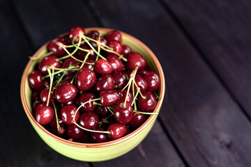 Cherry in a cup on a wooden background