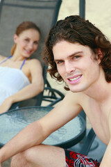 Man and woman relaxing on lounge chair at the beach